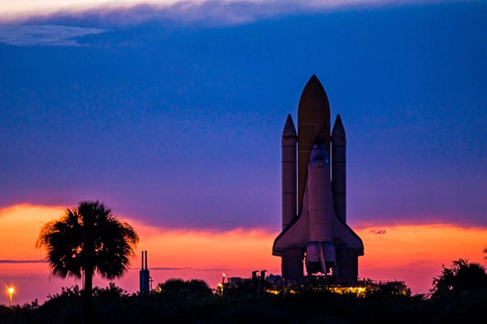 Space shuttle Discovery is silhouetted against the dawn sky